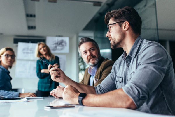 A team of colleagues gathered in a meeting room, deeply engrossed in a productive business discussion.