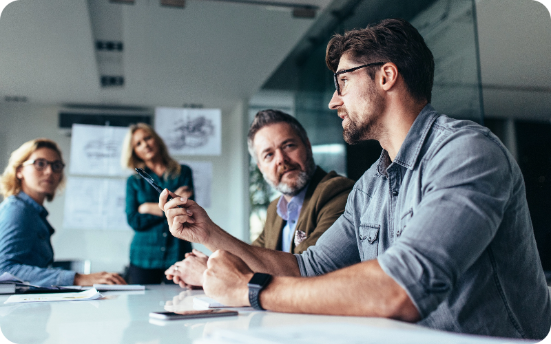 A team of colleagues gathered in a meeting room, deeply engrossed in a productive business discussion.